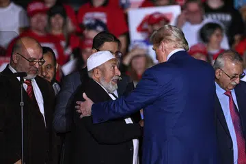 Calon Presiden dari Parti Republikan, Encik Donald Trump, bersama pemimpin komuniti Muslim yang menyokongnya di atas pentas semasa perhimpunan kempen di Suburban Collection Showplace di Novi, Michigan, pada 26 Oktober.