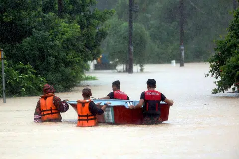 Pegawai penyelamat menjalani operasi semasa banjir melanda Kampung Pasir Tebrau di Johor pada awal 2025. 