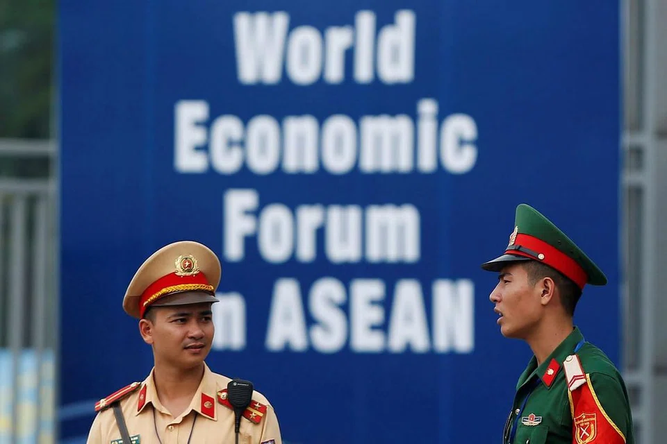 KAWAL: Seorang pegawai polis (kiri) dan pegawai polis tentera bertugas di luar Pusat Konvensyen Nasional di Hanoi. - Foto REUTERS 