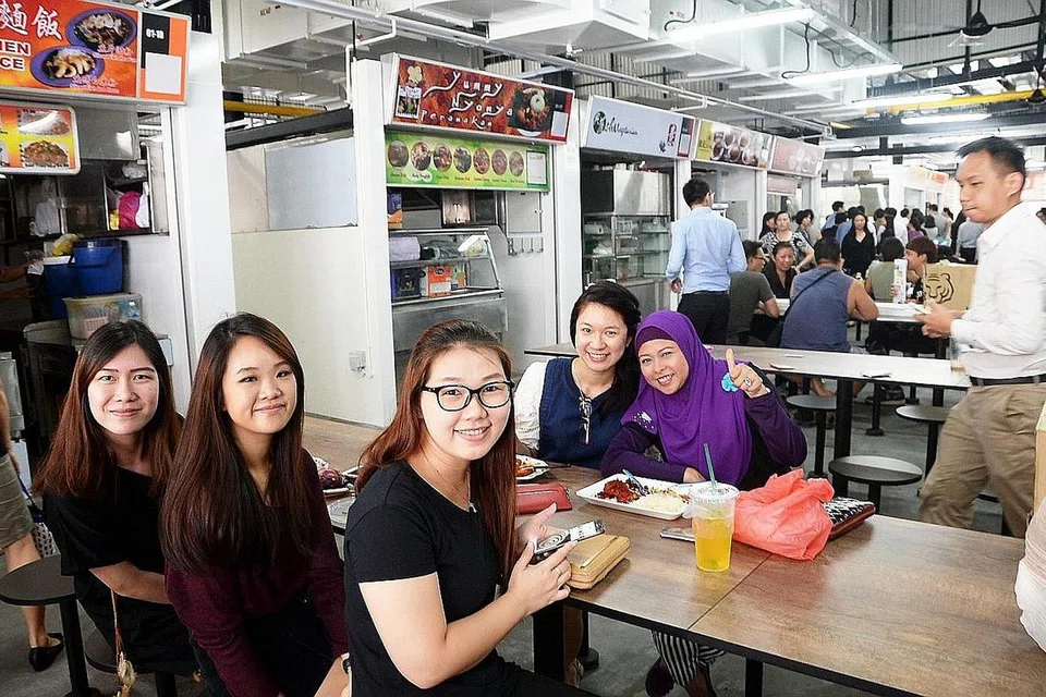  DARI GOLDEN SHOE KE CROSS STREET: Cik Norhayati (bertudung ungu) bersama rakan sekerjanya menjamu selera di pusat makanan sementara yang berpindah dari Golden Shoe ke Cross Street. - Foto JOHARI RAHMAT 