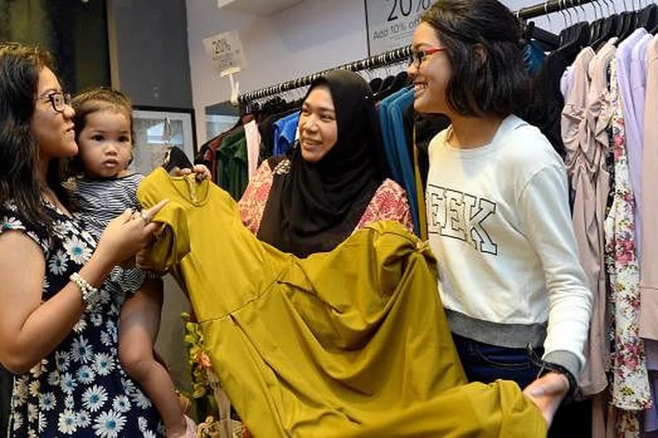 TERIMA PAKAIAN RAYA: Klien Skim Keluarga dan Belia Angkat (AFYS) AMP, Cik Zuraini Abdul Rahman (dua dari kanan), bersama tiga anak perempuannya (dari kiri) Zuraihana Johari, Zur Alisha dan Zur Ain, setiap seorang menerima pakaian raya percuma daripada butik Sufyaa semalam. - Foto-foto TAUFIK A. KADER