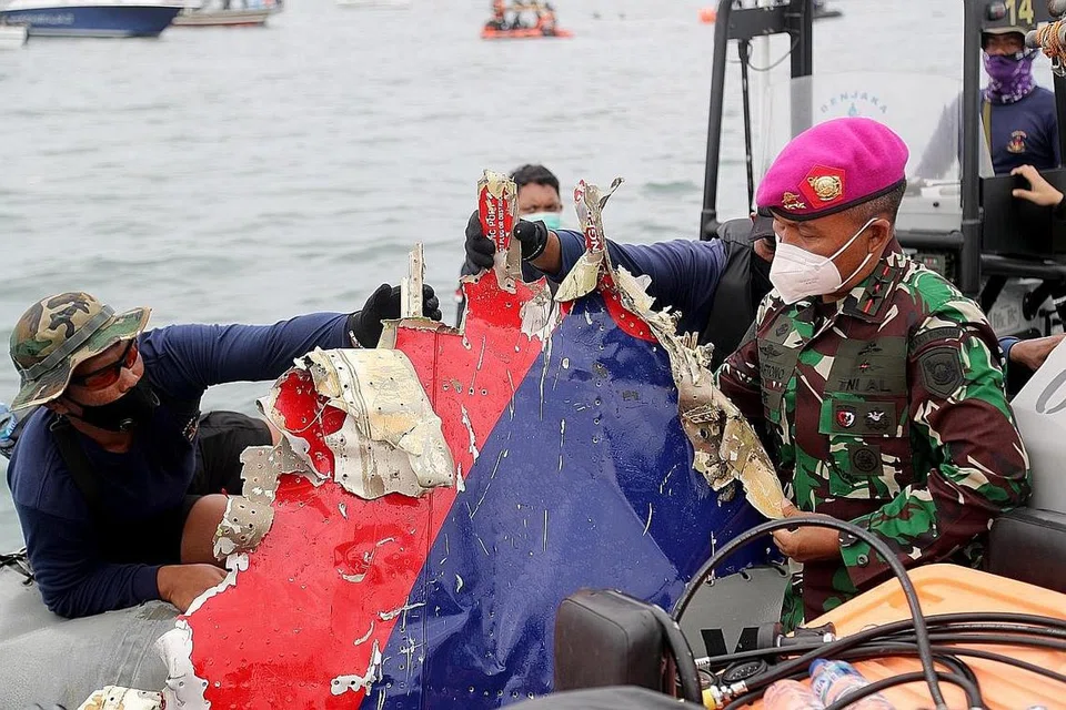 TEMUI SERPIHAN PESAWAT: Pegawai keselamatan Indonesia menunjukkan serpihan pesawat dalam sebuah bot ketika menjalankan operasi mencari dan menyelamat di kawasan perairan dekat Jakarta yang dipercayai lokasi terhempasnya pesawat Sriwijaya Air. - Foto EPA-EFE