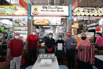 TERKEJUT TERIMA PENGHARGAAN: Pertama kali pengendali 'Mr Dum Briyani', pasangan suami isteri Encik Abddul Rauf (tiga dari kiri) dan Cik Masitah Mohamad (empat dari kiri) menerima penghargaan untuk beriani mereka. Bersama mereka (dari kiri) Encik Bernard Thia, Pengerusi Persatuan Peniaga West Coast Drive, Encik S Iswaran, Dr Fredrick Yap, Presiden IBF dan Cik Nor Suhir, ketua duta makanan IBF. - Foto BM oleh TIMOTHY DAVID