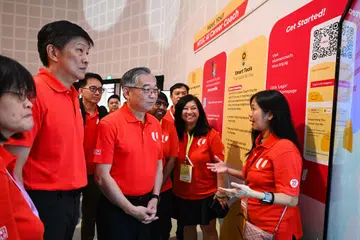 Timbalan Perdana Menteri Encik Gan Kim Yong (empat dari kiri), dan Setiausaha Agung Kongres Kesatuan Sekerja Kebangsaan (NTUC), Encik Ng Chee Meng (dua dari kiri), diberi taklimat tentang alat bimbing kerjaya semasa Persidangan Perwakilan Biasa (ODC) NTUC 2025 yang diadakan di D’Marquee, Downtown East, pada 13 November.