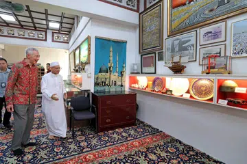 Habib Syed Hassan Syed Mohamed Salim Al-Attas atau lebih dikenali sebagai Habib Hassan (kanan) membawa Menteri Kanan, Encik Lee Hsien Loong, melihat artifak dan karya seni yang dipamerkan di muzium mini Masjid Ba’alwie. 