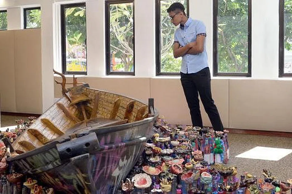 SENI MENDALAM: Seorang pengunjung meninjau hasil karya Encik Ahmad Abu Bakar - The Boat of Hope - yang bukan hanya indah dipandang mata, malah turut mempunyai makna mendalam. 