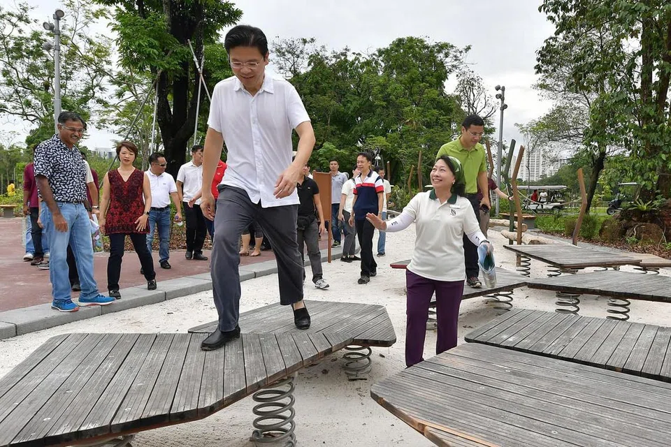 TAMAN BARU: Menteri Pembangunan Negara, Encik Lawrence Wong (depan) meninjau taman permainan, salah satu ciri menarik di Taman Lakeside. - Foto BM oleh NG SOR LUAN