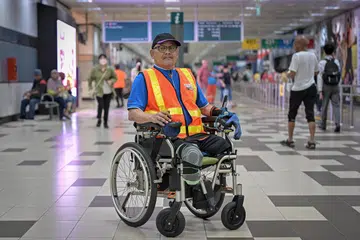 Encik Sazali Ismail bekerja sebagai rakan perjalanan atau travel buddy di Pusat Tukaran Bas Boon Lay. Beliau menggunakan kerusi roda setelah kedua-dua kakinya dipotong akibat jangkitan kuman 10 tahun lalu.