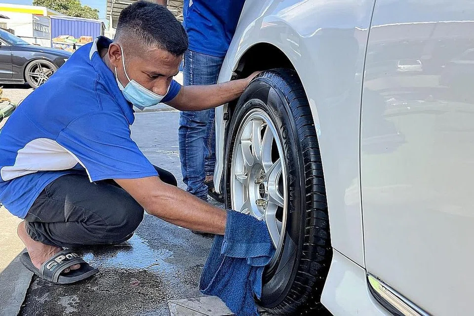KIAN SIBUK: Seorang pekerja di salah sebuah tempat mencuci kereta di Johor, dilihat terus sibuk dengan tugas membersihkan salah sebuah kereta milik pemandu Singapura.