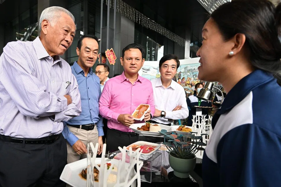 Seorang wakil Agensi Makanan Singapura (SFA) (kanan) memperkenalkan Hidangan Sedia untuk Dimakan kepada (dari kiri) Menteri Pertahanan, Dr Ng Eng Hen; Menteri Negara Kanan (Kemampanan dan Sekitaran merangkap Tenaga Manusia), Dr Koh Poh Koon; Menteri Negara Kanan (Pertahanan merangkap Tenaga Manusia), Encik Zaqy Mohamad; dan Menteri Negara Kanan (Pertahanan), Encik Heng Chee How. 