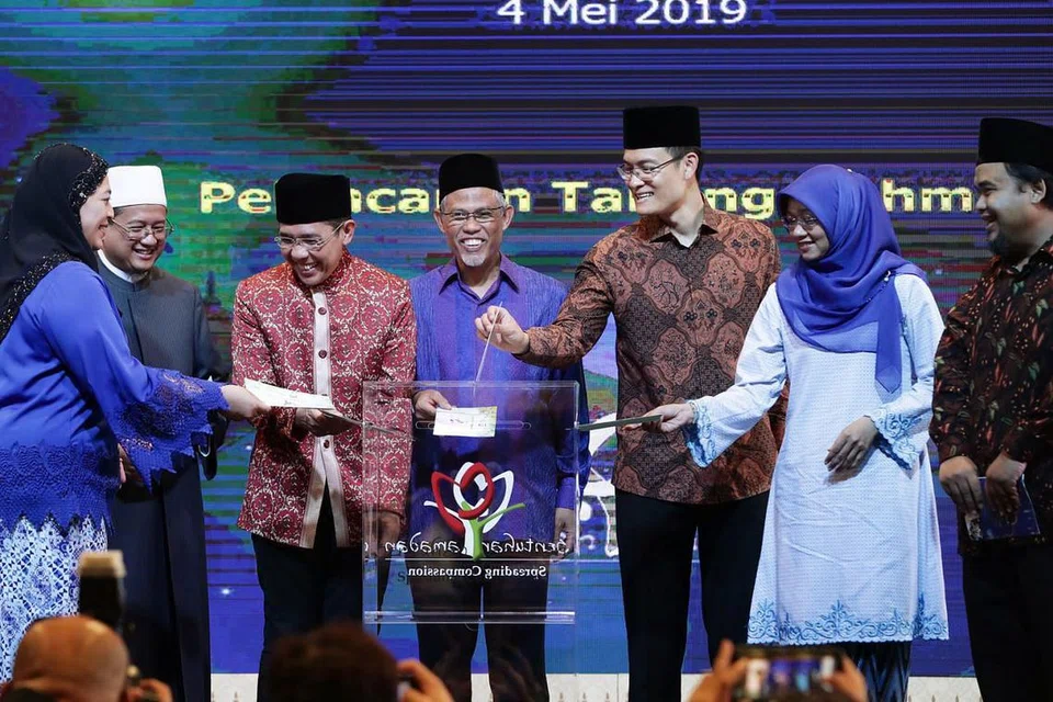 DERMA SIMBOLIK: (Dari kiri) Pengerusi Mesra, Cik Amatul Jameel Suhani Sujari; Mufti, Dr Mohamed Fatris Bakaram; Menteri Negara Kanan (Pertahanan merangkap Ehwal Luar), Dr Mohamad Maliki Osman; Menteri Bertanggungjawab bagi Ehwal Masyarakat Islam, Encik Masagos Zulkifli Masagos Mohamad; Ketua Eksekutif Majlis Ugama Islam Singapura (Muis), Encik Esa Masood; Ketua Pegawai Eksekutif (CEO) Mendaki, Cik Rahayu Buang; dan Pengerusi Kempen Sentuhan Ramadan 2019, Encik Izuan Mohd Rais, meletakkan 'derma simbolik' ke dalam tabung Sentuhan Ramadan 2019. - Foto BH oleh KELVIN CHNG
