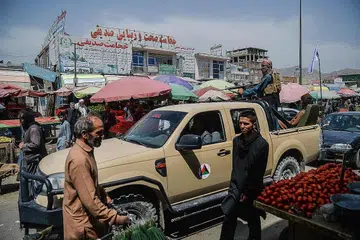 MASALAH MAKANAN: Tentera Taleban berada di atas trak yang bergerak di sekitar pasar yang dikunjungi penduduk Aghanistan di Kote Sangi, Kabul. - Foto AFP