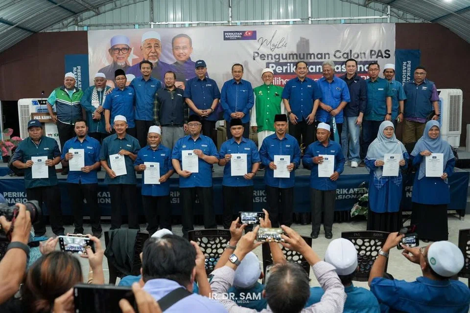 Pengerusi Perikatan Nasional (PN), Datuk Seri Dr Ahmad Samsuri Mokhtar (barisan kedua, tujuh dari kiri) bersama calon Parti Islam SeMalaysia (PAS) yang bertanding dalam Pilihan Raya Negeri Johor, pada majlis pengumuman calon di Muar, Johor, pada malam 25 Jun.