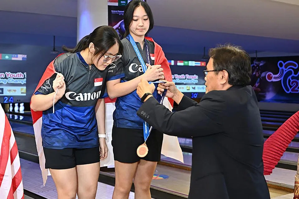 PINGAT GANGSA: (Dari kiri) Colleen Pee dan Arianne Tay menerima pingat gangsa dalam acara pasangan perempuan pada Kejohanan Boling Tenpin Asia ke-21 di Bangkok pada Isnin.