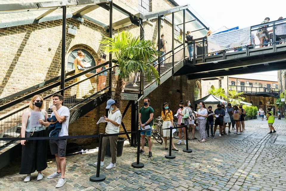 PUSAT VAKSINASI DI TENGAH BANDAR: Para penduduk setempat beratur panjang di pusat vaksinasi sementara bagi Covid-19 di Pasar Camden di London, Britain. - Foto EPA-EFE