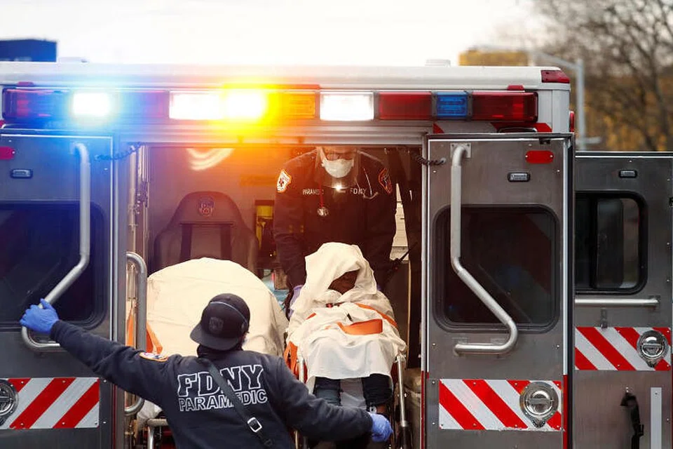 SAAT KECEMASAN: Para petugas perubatan memakai pakaian pelindungan diri sedang mereka segera membawa seorang pesakit yang mengalami serangan jantung di depan Howard Houses ke hospital sedang penularan jangkitan koronavirus terus merebak di kawasan Brooklyn, New York, Amerika Syarikat