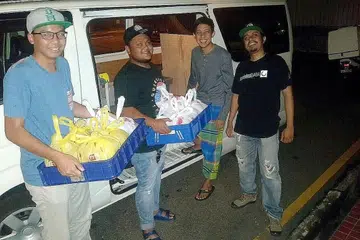 SIAP DIHANTAR: Encik Muhammad Fazly (dua dari kiri) sedang bersiap menghantar makanan ke rumah pelanggan untuk dimakan waktu sahur. - Foto KASSIMBABA