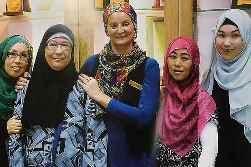 BIMBING PELAWAT MASJID: Sebahagian pemandu pelawat sukarela Masjid Sultan. Di kanan ialah Cik Aishah Miwa Kondo. - Foto daripada buku 'Masjid Sultan'. 