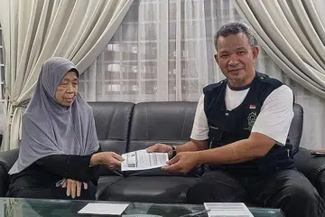 MAHU TERUS BERBAKTI: Encik Abu Bakar Haji Abdul Rahim mambantu nmengutip sumbangan daripada salah seorang penyumbang, Hajah Sariyah Haji Marmin. - Foto-foto AL-IMTAQ INTERNATIONAL & SERVICES