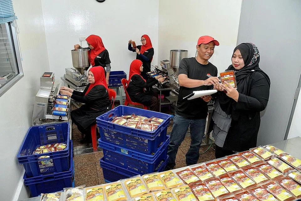 PERMINTAAN PES MENINGKAT: Cik Norhuda Rabani (paling kanan) dengan pekerjanya di kilang menghasilkan produk pes dibawah jenama Asyura Paste. Gambar ini diambil pada 2016. - Foto fail