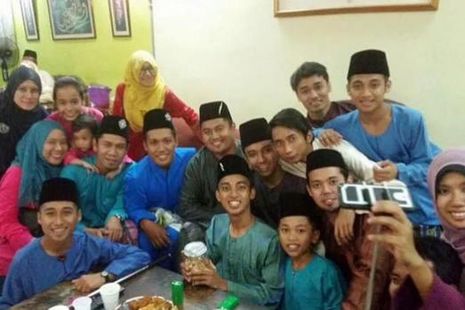 MERIAHNYA LEBARAN BERAMAI-RAMAI: Pemain sayap LionsXII, Faris Ramli (memegang botol kuih) beraya di rumah sanak saudara. - Foto FARIS RAML