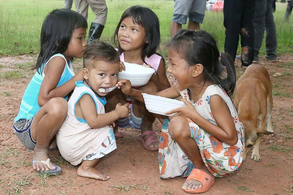 BANTUAN MAKANAN: Kanak-kanak menikmati bubur di pusat pemindahan Sanamxay. 