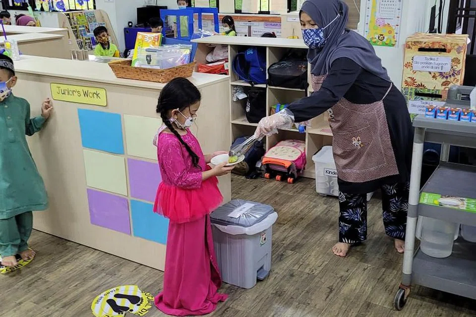MAKAN DENGAN SELAMAT:Kanak-kanak di prasekolah Kidz Meadow ini harus beratur dengan jarak selamat sebelum mengambil sajian semasa waktu makan. - Foto KIDZ MEADOW