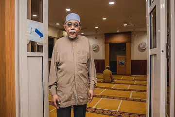TERUS BERBAKTI KEPADA MASYARAKAT: Kini berusia 74 tahun, Ustaz Mohamad H Rais, masih aktif menjalankan kerja-kerja kemasyarakatan dan menjadi relawan di beberapa masjid setempat. - Foto BH oleh NUR DIYANA TAHA