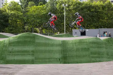 Dua pelumba BMX sedang mencuba pump track di The Bricks: Sport-In-Precinct & Cycle Park semasa pelancaran tidak rasmi kemudahan tersebut yang terletak di Choa Chu Kang pada Ogos 2025.