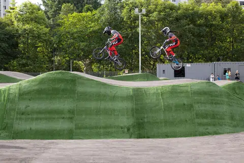 Dua pelumba BMX sedang mencuba pump track di The Bricks: Sport-In-Precinct & Cycle Park semasa pelancaran tidak rasmi kemudahan tersebut yang terletak di Choa Chu Kang pada Ogos 2025.