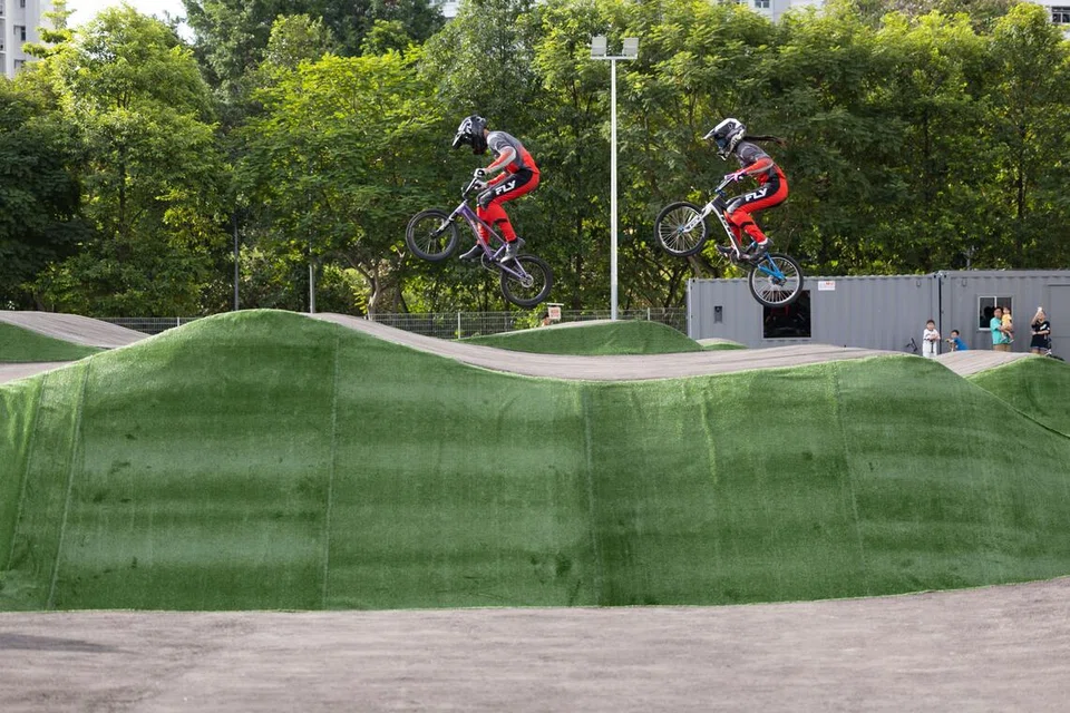 Dua pelumba BMX sedang mencuba pump track di The Bricks: Sport-In-Precinct & Cycle Park semasa pelancaran tidak rasmi kemudahan tersebut yang terletak di Choa Chu Kang pada Ogos 2025.