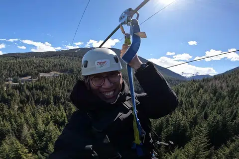 Menikmati pengalaman mendebarkan menaiki zipline di Whistler, dengan panorama indah gunung dan hutan di sekeliling.