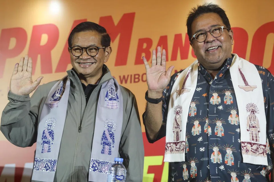 Calon Gabenor Jakarta, Encik Pramono Anung (kiri), dan calon Timbalan Gabenor, Encik Rano Karno, melambai kepada wartawan semasa sidang media pilihan raya pemerintah daerah di Jakarta pada 27 November.
