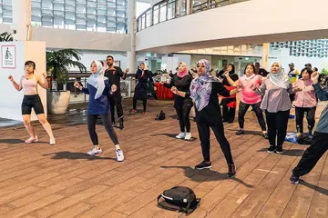 SENANG SENAM: Cik Rahayu (dua dari kiri) menyertai peserta 'Senang Senam' serta anggota keluarga dan rakan mereka semasa acara finale program itu di PAssion WaVe @ Jurong Lake Gardens.