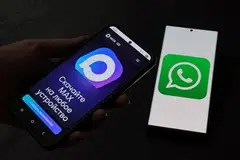 Halaman web aplikasi pemesejan Russia, MAX, dipaparkan pada skrin telefon pintar bersebelahan skrin yang memaparkan logo WhatsApp, dalam ilustrasi yang diambil pada 21 Julai 2025. Russia mengehadkan perkhidmatan panggilan melalui aplikasi pemesejan WhatsApp dan Telegram, yang didakwa bagi melindungi negara daripada ancaman pengganas dan penipuan