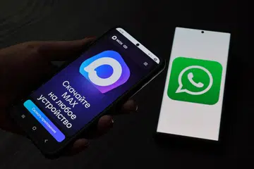 Halaman web aplikasi pemesejan Russia, MAX, dipaparkan pada skrin telefon pintar bersebelahan skrin yang memaparkan logo WhatsApp, dalam ilustrasi yang diambil pada 21 Julai 2025. Russia mengehadkan perkhidmatan panggilan melalui aplikasi pemesejan WhatsApp dan Telegram, yang didakwa bagi melindungi negara daripada ancaman pengganas dan penipuan
