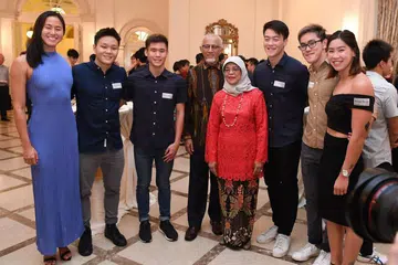 PENCAPAIAN DIHARGAI: Presiden Halimah (empat dari kanan) sempat bergambar dan bermesra dengan para atlit serta pegawai yang diiktiraf pencapaian mereka dalam lima sukan luar negara tahun lalu. - Foto BH oleh DESMOND FOO