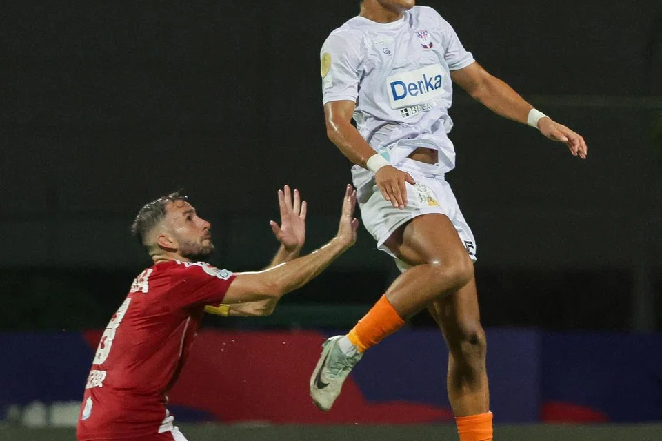 Shingo Nakano (berbaju putih) menentang Alen Kozar (berbaju merah) dari Balestier Khalsa FC untuk menerima hantaran bola dari tinggi sewaktu perlawanan Liga Perdana Singapura (SPL) pada Sept 2024.