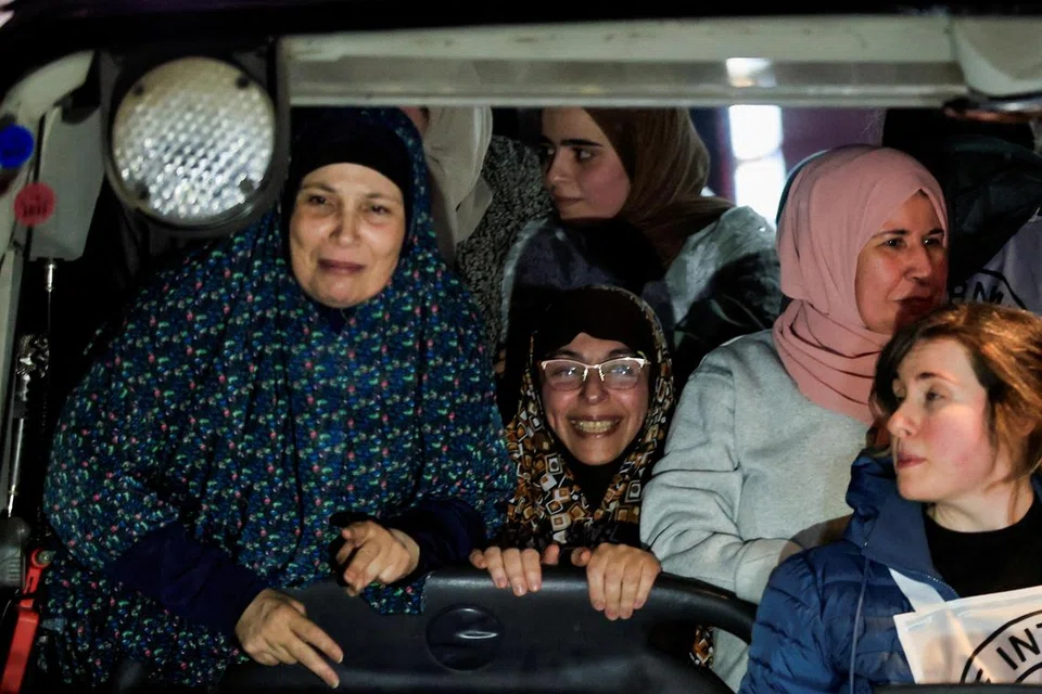 
Tahanan Palestin yang dibebaskan menunjukkan reaksi dari dalam sebuah bas yang membawa mereka selepas pembebasan mereka dari penjara Israel, sebagai sebahagian daripada perjanjian gencatan senjata di Gaza.