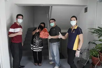 MENGHULUR BANTUAN: Cik Salimah (dua dari kiri) gembira menerima makanan daripada Encik Chua Jeng-Chii, pengurus sokongan perniagaan dan perancangan di SATs (kiri), Encik Yap Keng Hwee, pengarah bersekutu, Yayasan Temasek dan Cik Jaime Yeastman, Pengurus Dalam Penerbangan SIA (kanan) semasa pengagihan makanan kepada benefisiari di estet Lengkok Bahru semalam. - Foto TEMASEK FOUNDATION