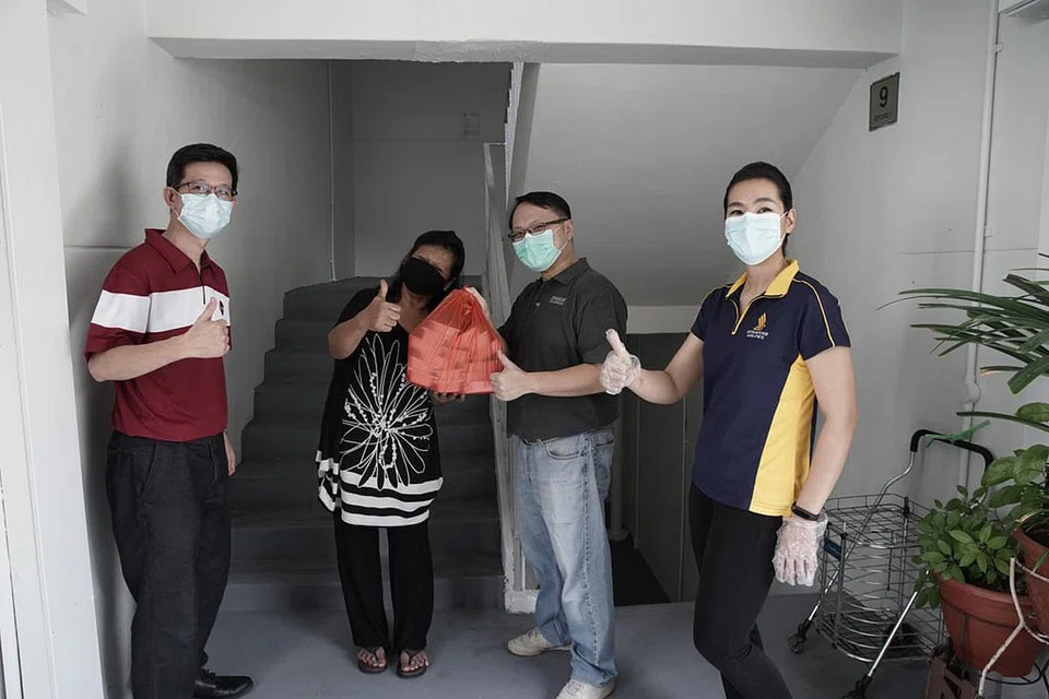 MENGHULUR BANTUAN: Cik Salimah (dua dari kiri) gembira menerima makanan daripada Encik Chua Jeng-Chii, pengurus sokongan perniagaan dan perancangan di SATs (kiri), Encik Yap Keng Hwee, pengarah bersekutu, Yayasan Temasek dan Cik Jaime Yeastman, Pengurus Dalam Penerbangan SIA (kanan) semasa pengagihan makanan kepada benefisiari di estet Lengkok Bahru semalam. - Foto TEMASEK FOUNDATION