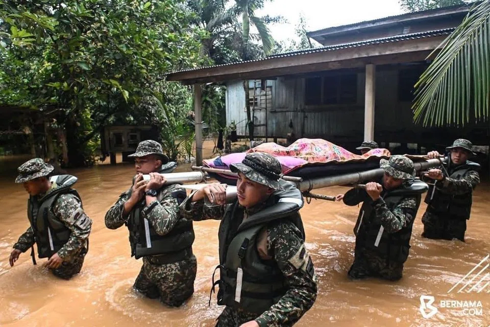 GANDING BAHU: Anggota Angkatan Tentera Malaysia (ATM) terpaksa meredah banjir mengusung jenazah seorang warga emas, Allahyarham Cik Kelthom Mat, 84 tahun, yang meninggal dunia akibat sakit tua di rumahnya di Kampung Bukit Tadok, Kuala Terengganu, Terengganu, pada 25 Januari.