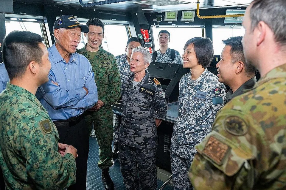 PELUANG BEKERJASAMA: Menteri Pertahanan Dr Ng Eng Hen beramah mesra dengan anggota SAF dan Pasukan Pertahanan Australia yang menyertai Latihan Trident ketika berada di kapal induk HMAS Adelaide. - Foto MINDEF