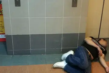 TIDAK SEDARKAN DIRI: Seorang bekas penagih dilihat tergelimpang selepas menghisap mushroom di ruang lif sebuah blok di Bedok North Street 3. - Foto oleh PEMBACA BM