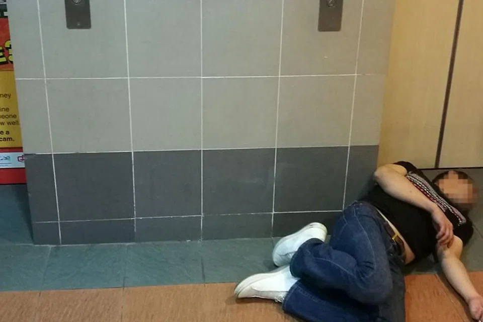 TIDAK SEDARKAN DIRI: Seorang bekas penagih dilihat tergelimpang selepas menghisap mushroom di ruang lif sebuah blok di Bedok North Street 3. - Foto oleh PEMBACA BM