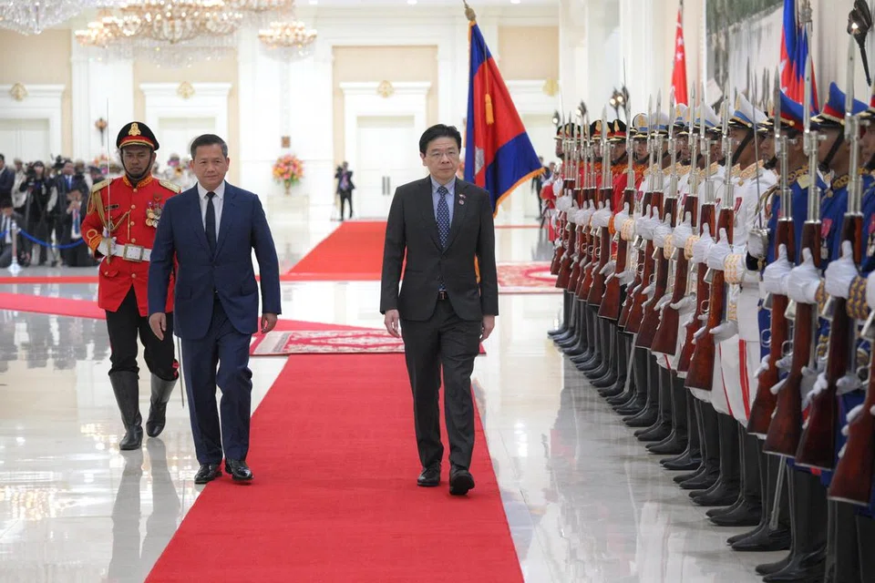 Perdana Menteri, Encik Lawrence Wong (kanan), yang diiringi Perdana Menteri Kemboja, Encik Hun Manet, disambut perbarisan kehormat sebagai sebahagian daripada upacara sambutan di Istana Keamanan di Phnom Penh, Kemboja, pada 2 Julai 2025.