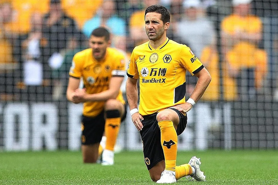 LAMBANG TANGANI DISKRIMINASI: Pemain Wolverhampton Wanderer Joao Moutinho berlutut sebagai memberi sokongan terhadap usaha menentang diskriminasi dalam bola sepak, sebelum perlawanan menentang Norwich City. - Foto REUTERS