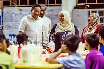 BERAMAH MESRA: Encik Amrin (kiri) bersama ahli psikologi pendidikan yang juga sukarelawan RKM, Dr Sharifah Mariam Aljunied (dua dari kanan), dan dua kakitangan RKM bersahur bersama kanak-kanak rumah kebajikan itu semalam. - Foto FACEBOOK AMRIN AMIN