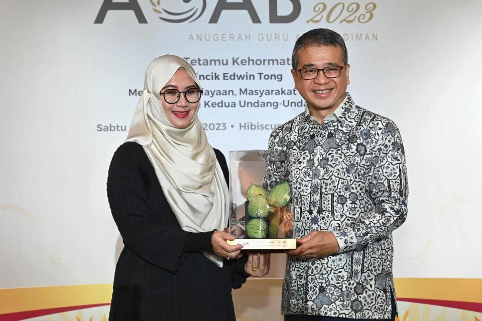 PENGIKTIRAFAN: Encik Edwin Tong sampaikan Anugerah Guru Arif Budiman kepada pemenang.