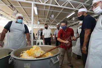 BERIANI SEDAP TIDAK TERKATA: Tetamu terhormat acara pengedaran beriani, Encik Edwin Tong, semalam mengacau nasi beriani terkenal Masjid Khalid sambil disaksikan pengerusinya Encik Alla'udin Mohamed (dua dari kanan) dalam kerjasama sulung ETF dan masjid tersebut. Turut bersama mereka ialah mayor CDC South East Fahmi Aliman (dua dari kiri) dan pengerusi jawatankuasa ETF Abdul Razak Hassan Maricar (tiga dari kiri). - Foto BM oleh TIMOTHY DAVID